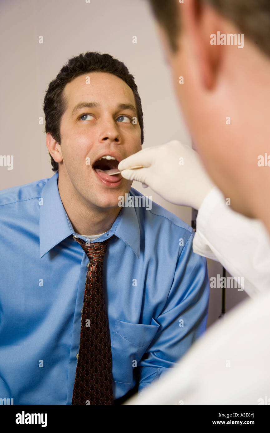 Arzt untersucht Patienten Mund und Zunge. Stockfoto