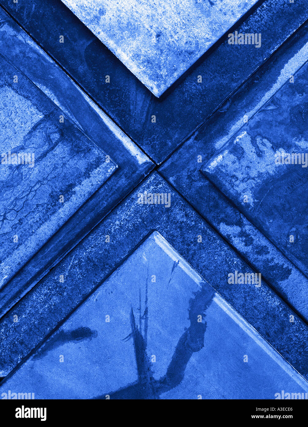 Abstrakte geometrische Stillleben mit sich kreuzenden verwitterte Stahl Dreiecke mit blauen Farbstich Stockfoto