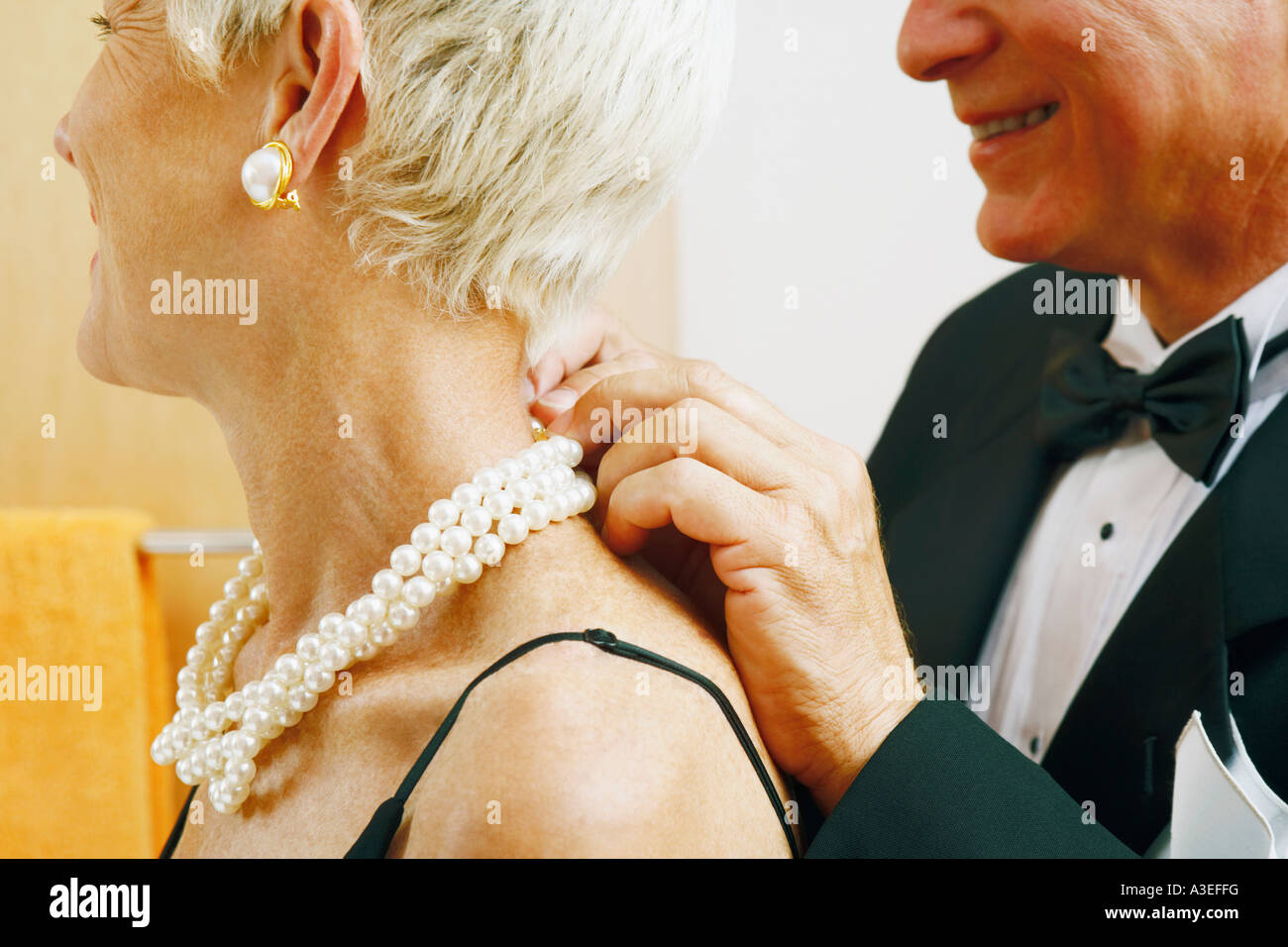 Nahaufnahme eines reifen Mannes setzen eine Perlenkette um eine reife Frau  Hals Stockfotografie - Alamy