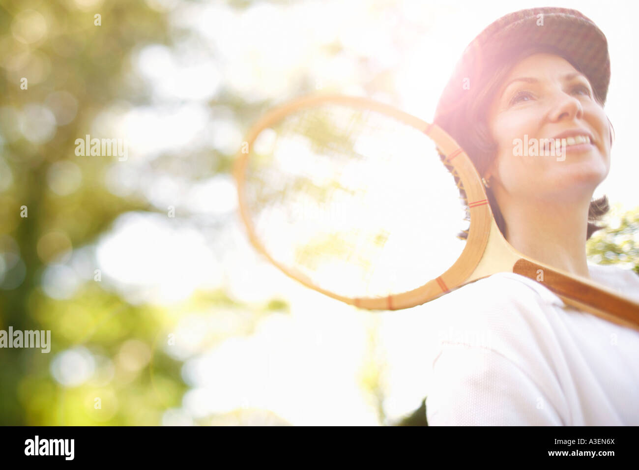 Niedrigen Winkel Ansicht einer Mitte erwachsenen Frau hält einen Tennisschläger und lächelnd Stockfoto