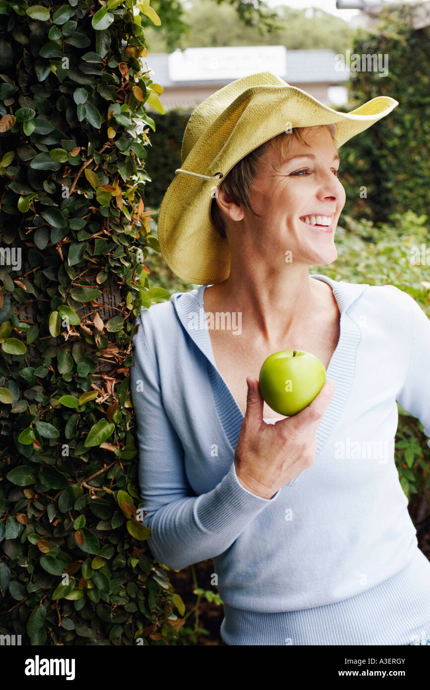 Nahaufnahme einer reifen Frau hält einen Granny Smith Apfel Stockfoto