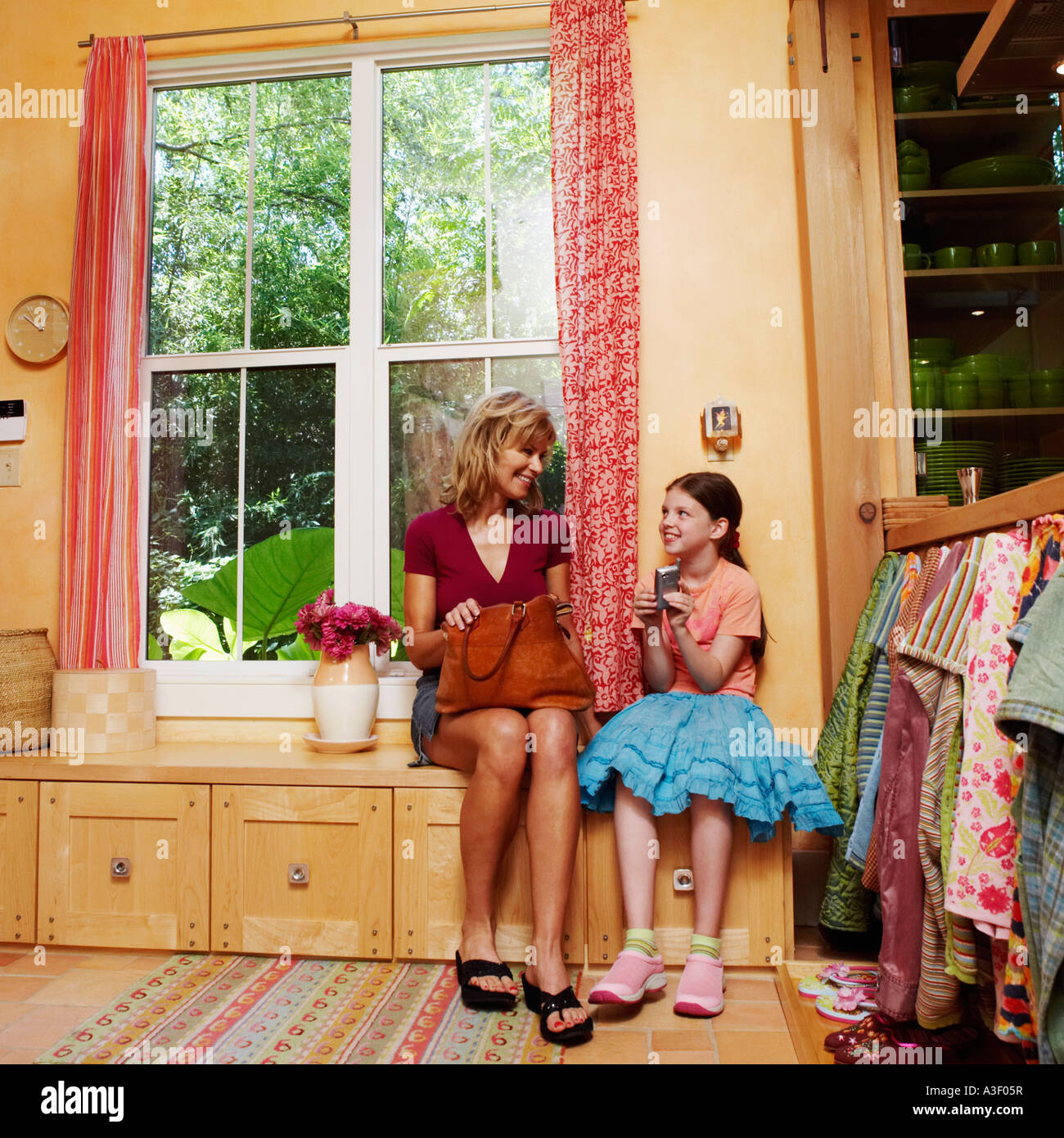 Reife Frau mit ihrer Tochter auf einem Schrank sitzen Stockfoto