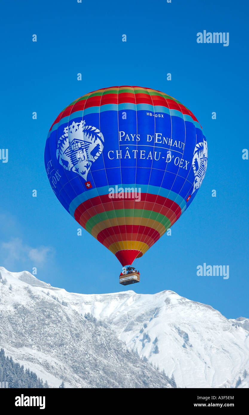 Chateau d ' Oex Ballon fliegen über einen verschneiten Bergrücken Stockfoto