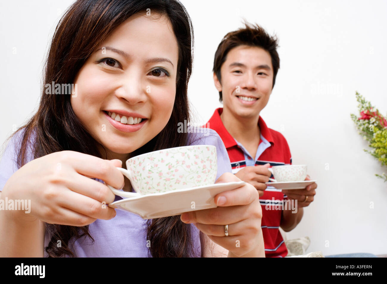 Porträt einer jungen Frau und eine Mitte erwachsener Mann Tee trinken Stockfoto