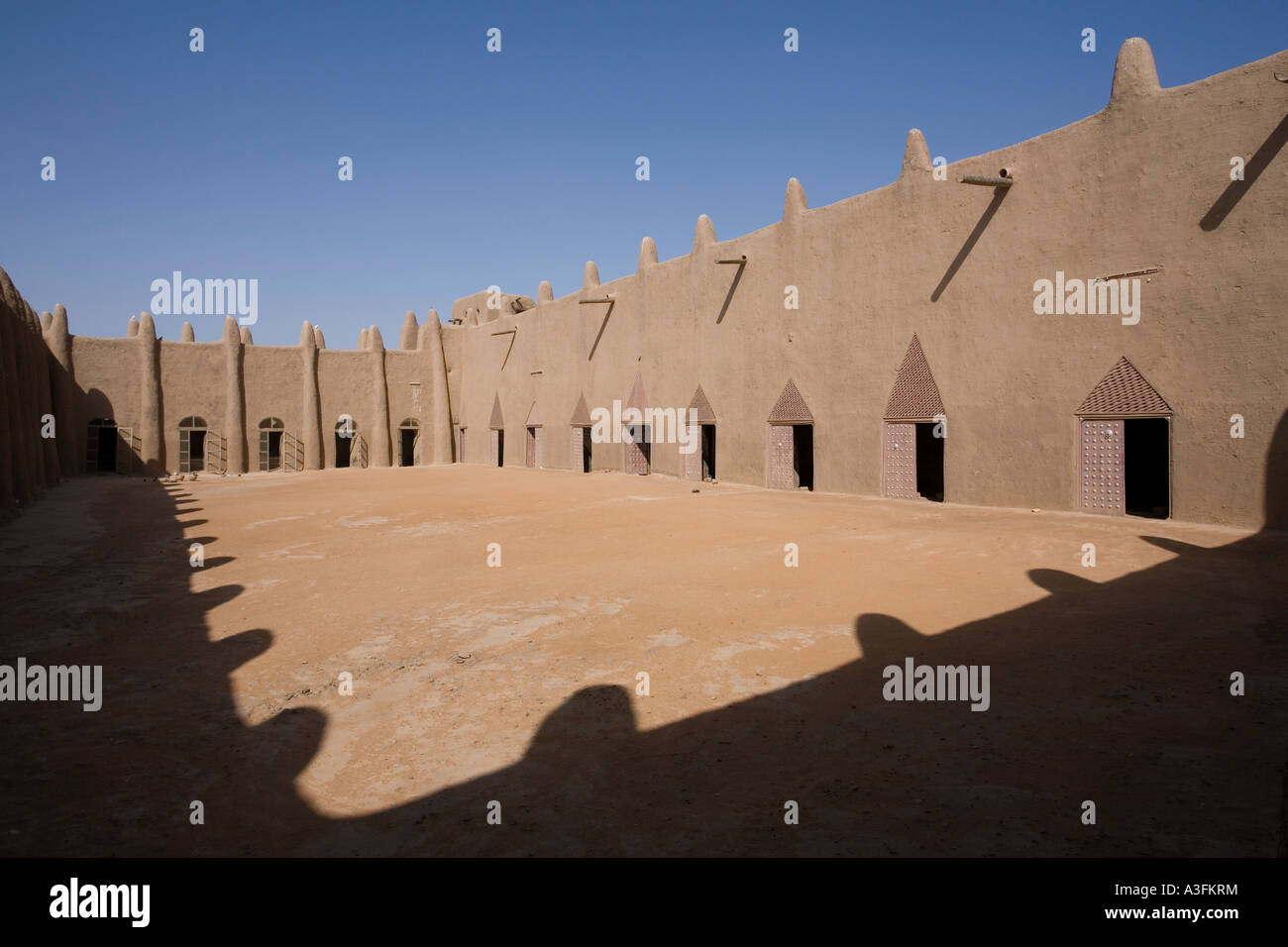 Der Innenhof der Moschee von Djenné mit vielen Türen und krassen Schatten zeigen die Gipfel auf dem Dach Stockfoto
