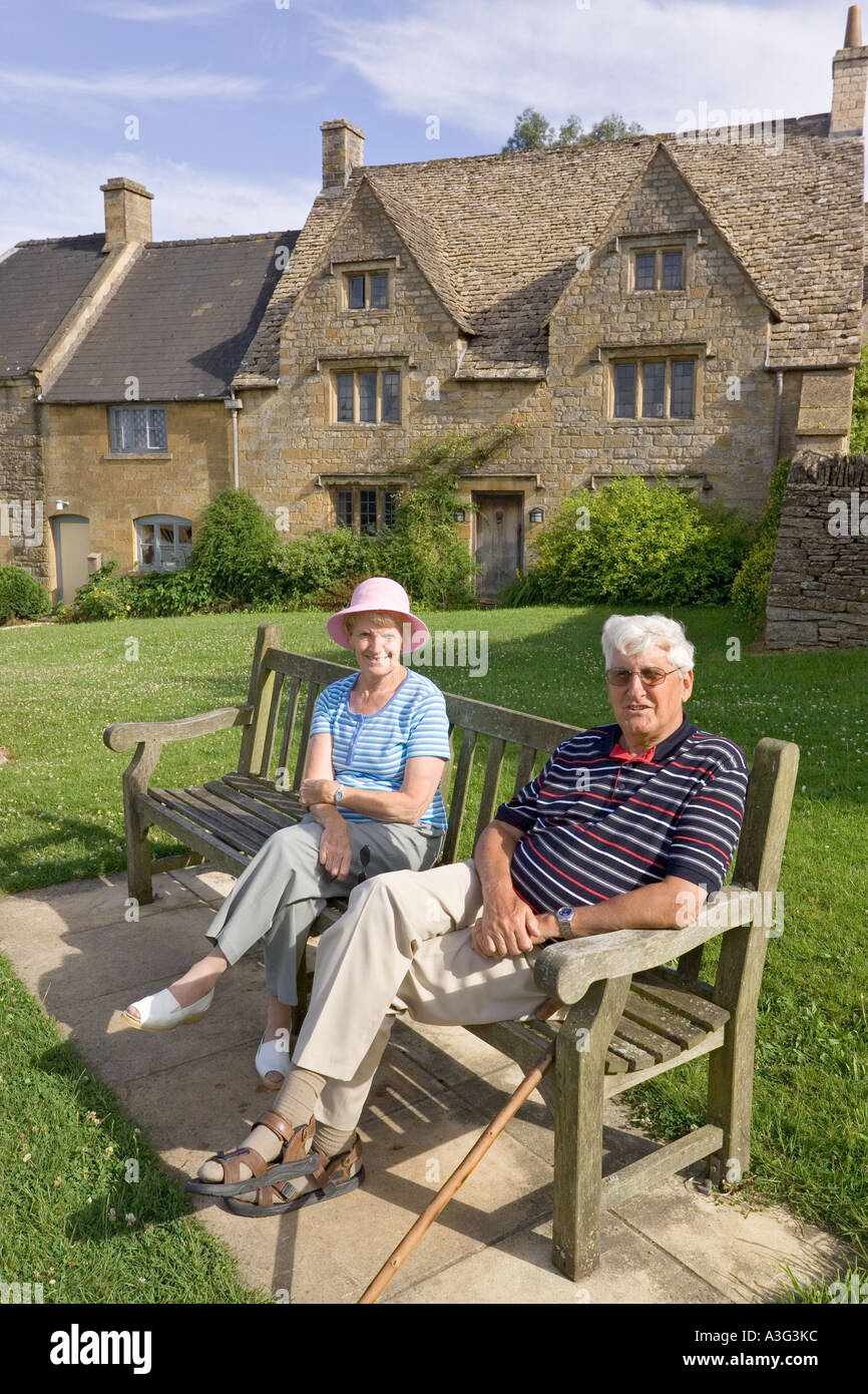 Besucher genießen die Sonne am frühen Abend im Cotswold Dorf der Guiting macht, Gloucestershire Stockfoto