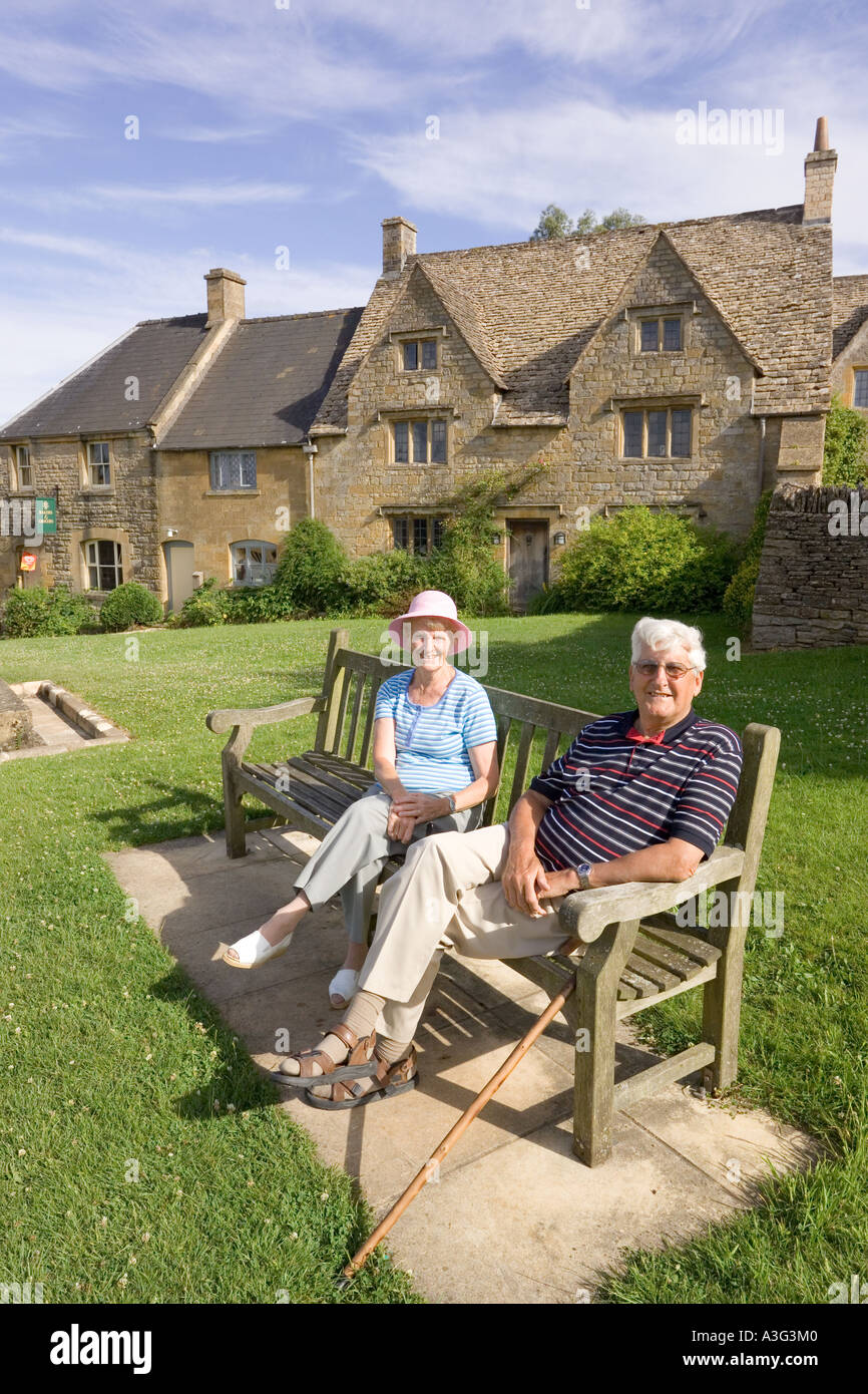 Besucher genießen die Sonne am frühen Abend im Cotswold Dorf der Guiting macht, Gloucestershire Stockfoto