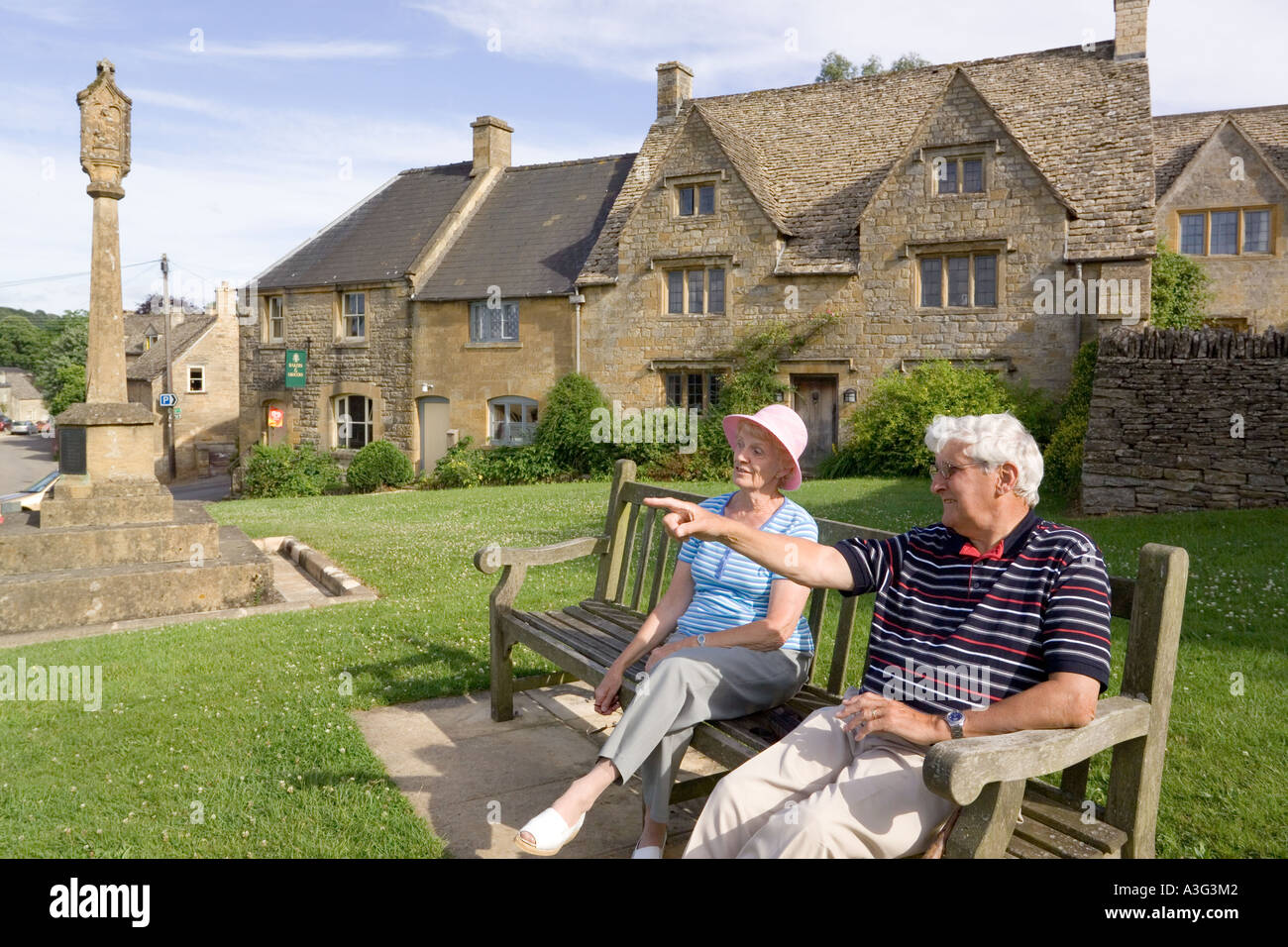 Besucher genießen die Sonne am frühen Abend im Cotswold Dorf der Guiting macht, Gloucestershire Stockfoto