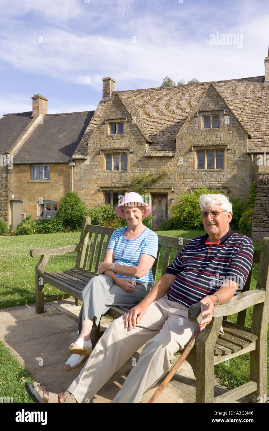 Besucher genießen die Sonne am frühen Abend im Cotswold Dorf der Guiting macht, Gloucestershire Stockfoto