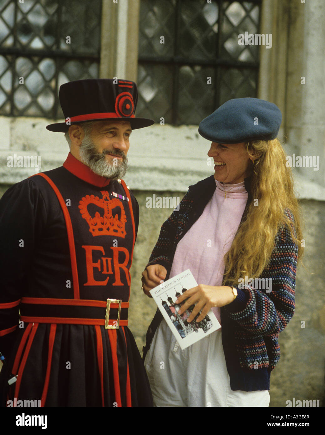 lächelnde Frau touristisch attraktiven posiert für Bild mit Beefeater Yeoman Wache am Tower of London Stockfoto