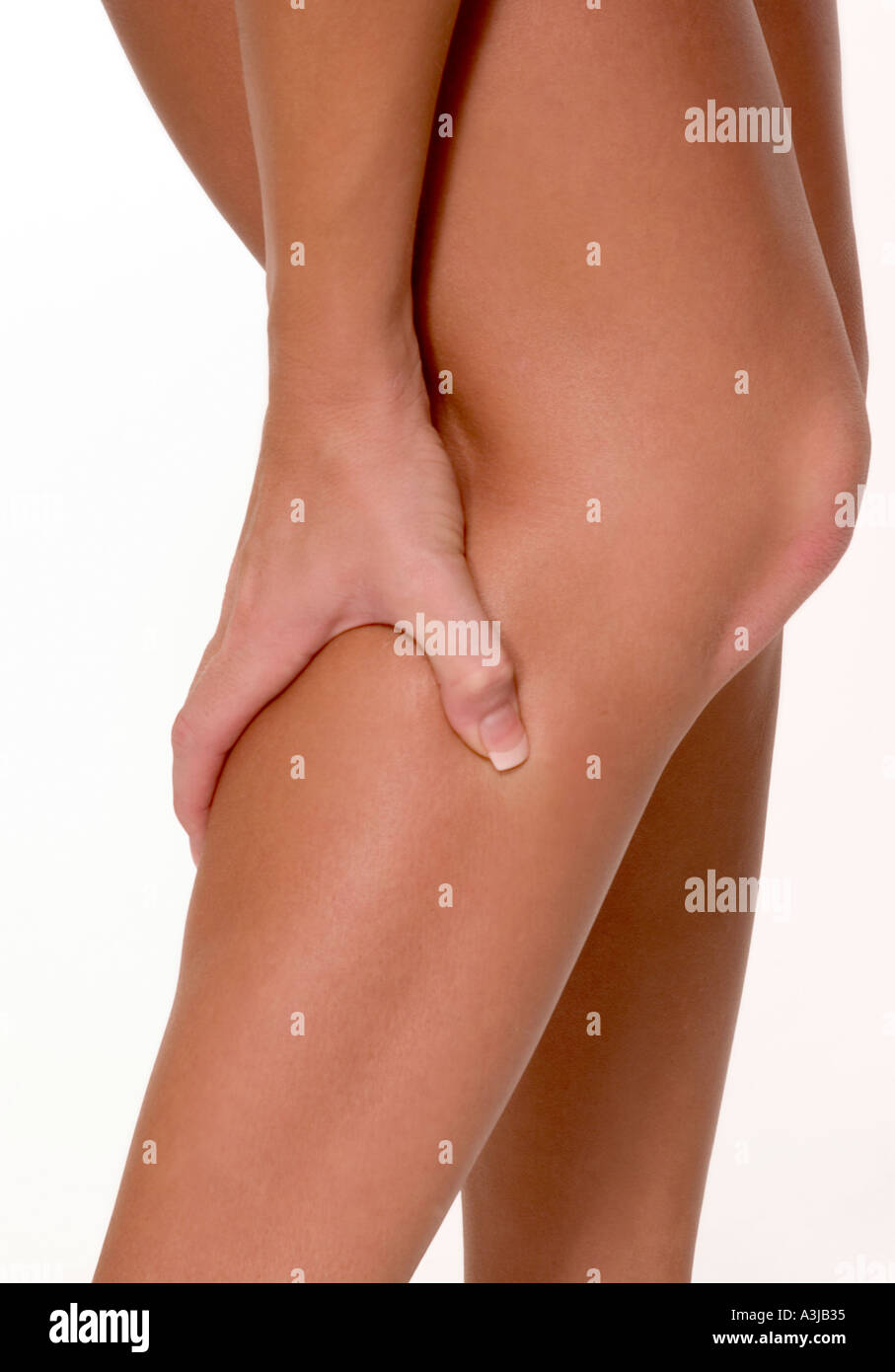 Mädchen, das ein Bein mit Schmerzen von einem Charley-Pferd-Muskelkrampf umklammert. USA. Stockfoto