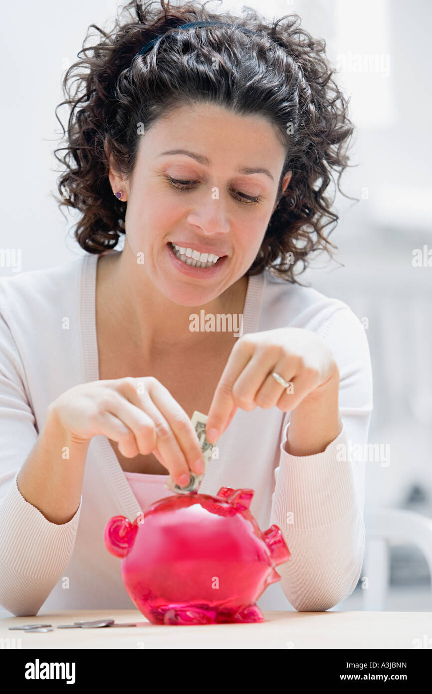 Frau, Geld im Sparschwein Stockfoto