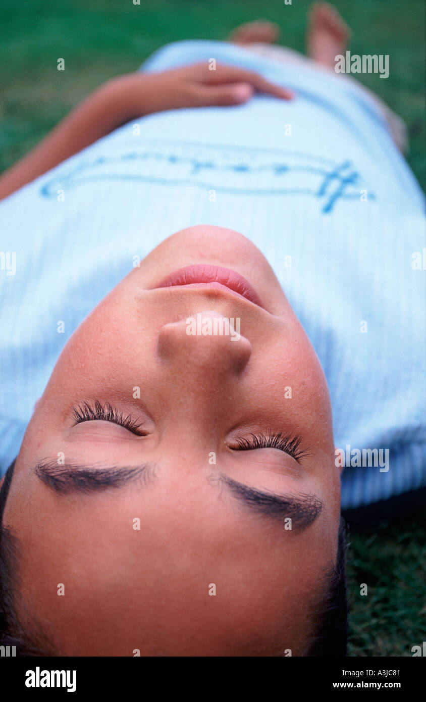 Weitwinkel-Ansicht von einem Teenager auf dem Rasen liegend Stockfoto