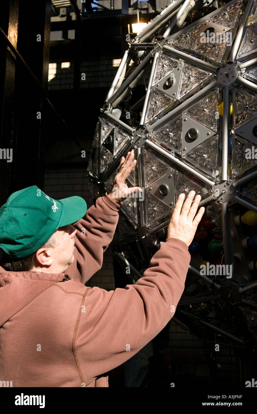 Ein Arbeiter installiert man 72 Waterford Kristall Dreiecke mit der Hoffnung für Fellowship-Design an der Außenseite des Times Sq Stockfoto