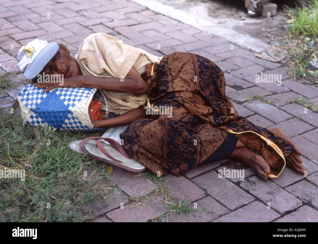 Ältere lokale Obdachlose schlafen auf dem Bürgersteig im Laufe des Tages in Madiun Ost-Java Indonesien Stockfoto