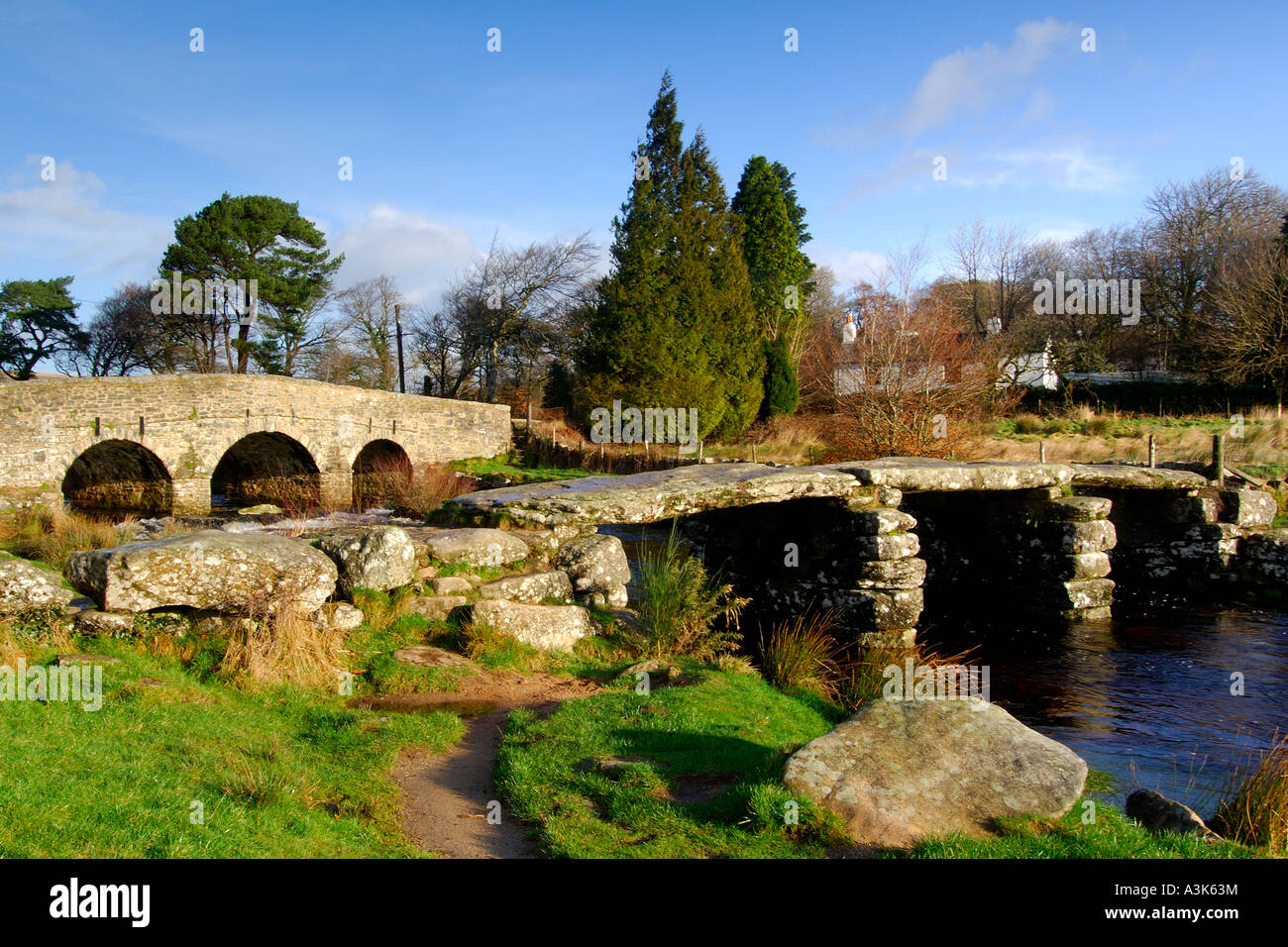 Dorf postbridge Dartmoor zeigt sowohl die neueren Stein Road Bridge Crossing und der alten aus dem 14. Jahrhundert clapper Bridge Stockfoto