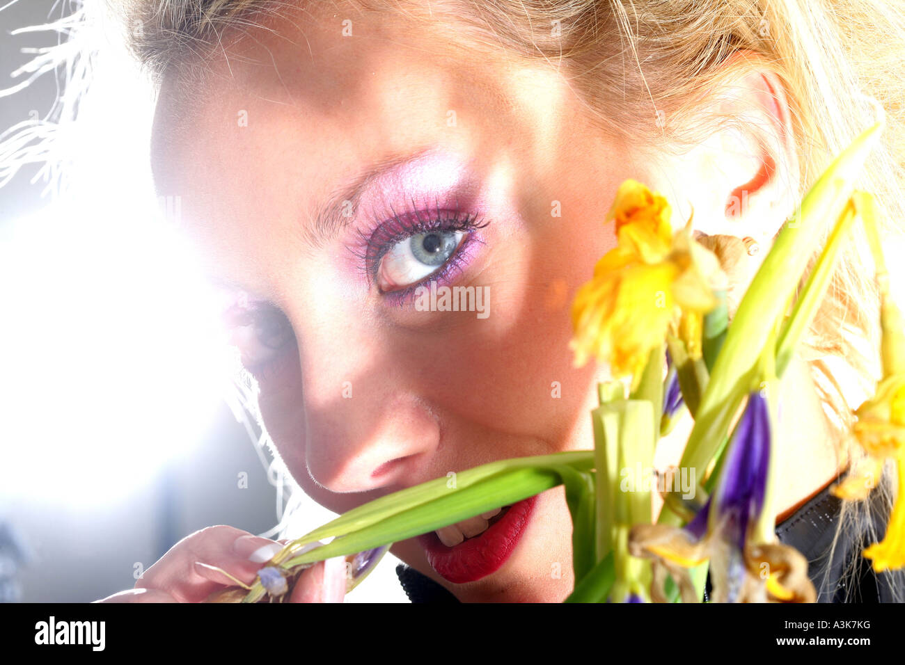 Störend oder gestörte junge Frau in schwarzes Leder gekleidet, hält ein Bündel von toten Blumen gegen einen weißen Hintergrund mit einen Freistellungspfad isoliert Stockfoto
