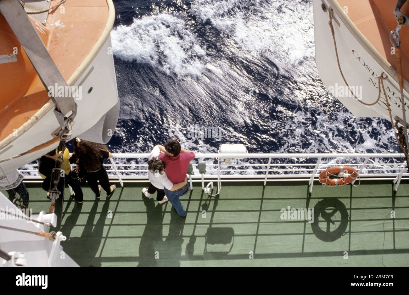 An Bord-Kreuzfahrtschiff im Mittelmeer paar Arm in Arm neben Deck Schienen zwischen Rettungsboote Wellen Stockfoto