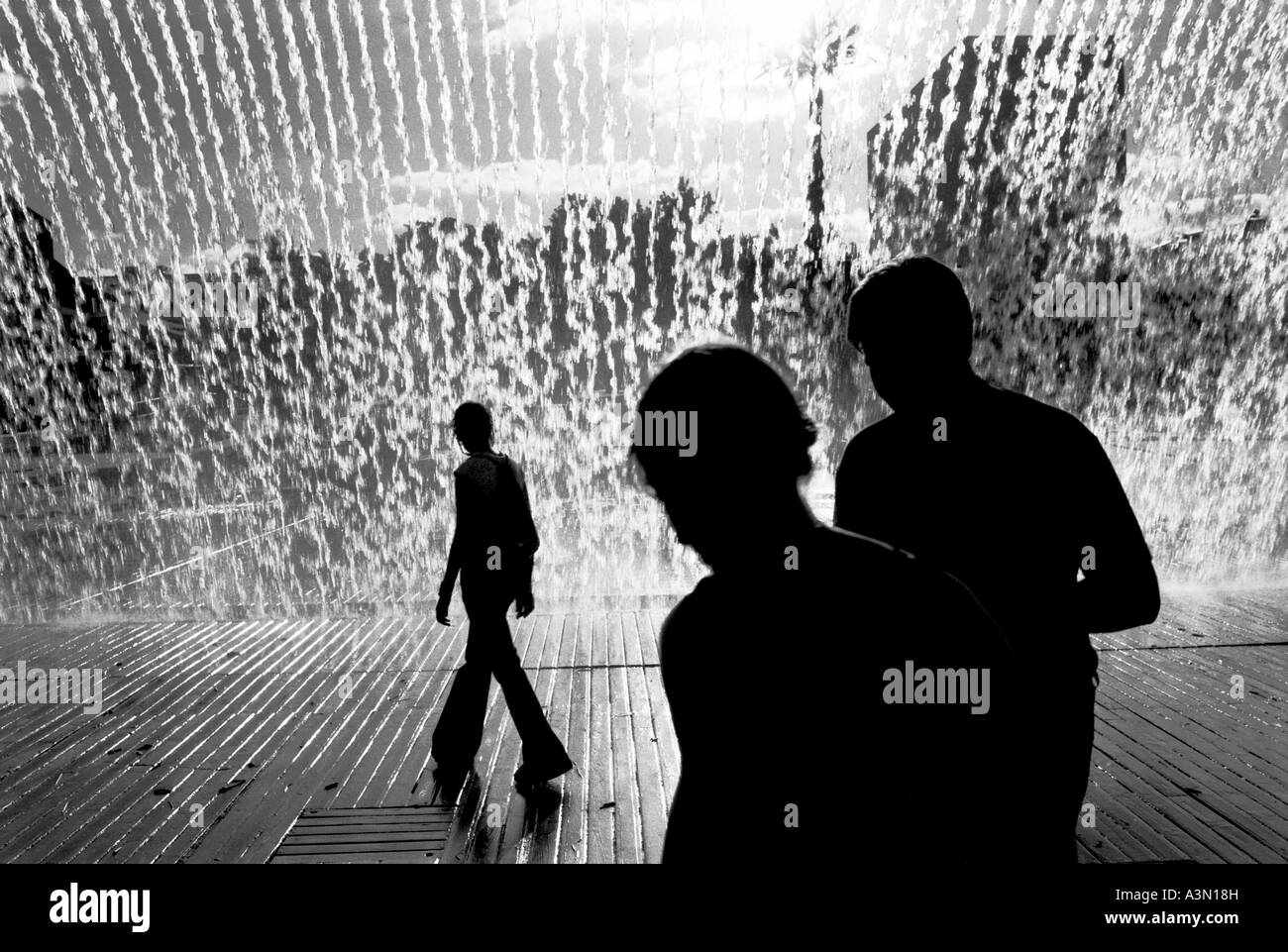 Passanten in der Nähe von einem künstlichen Wasserfall Stockfoto