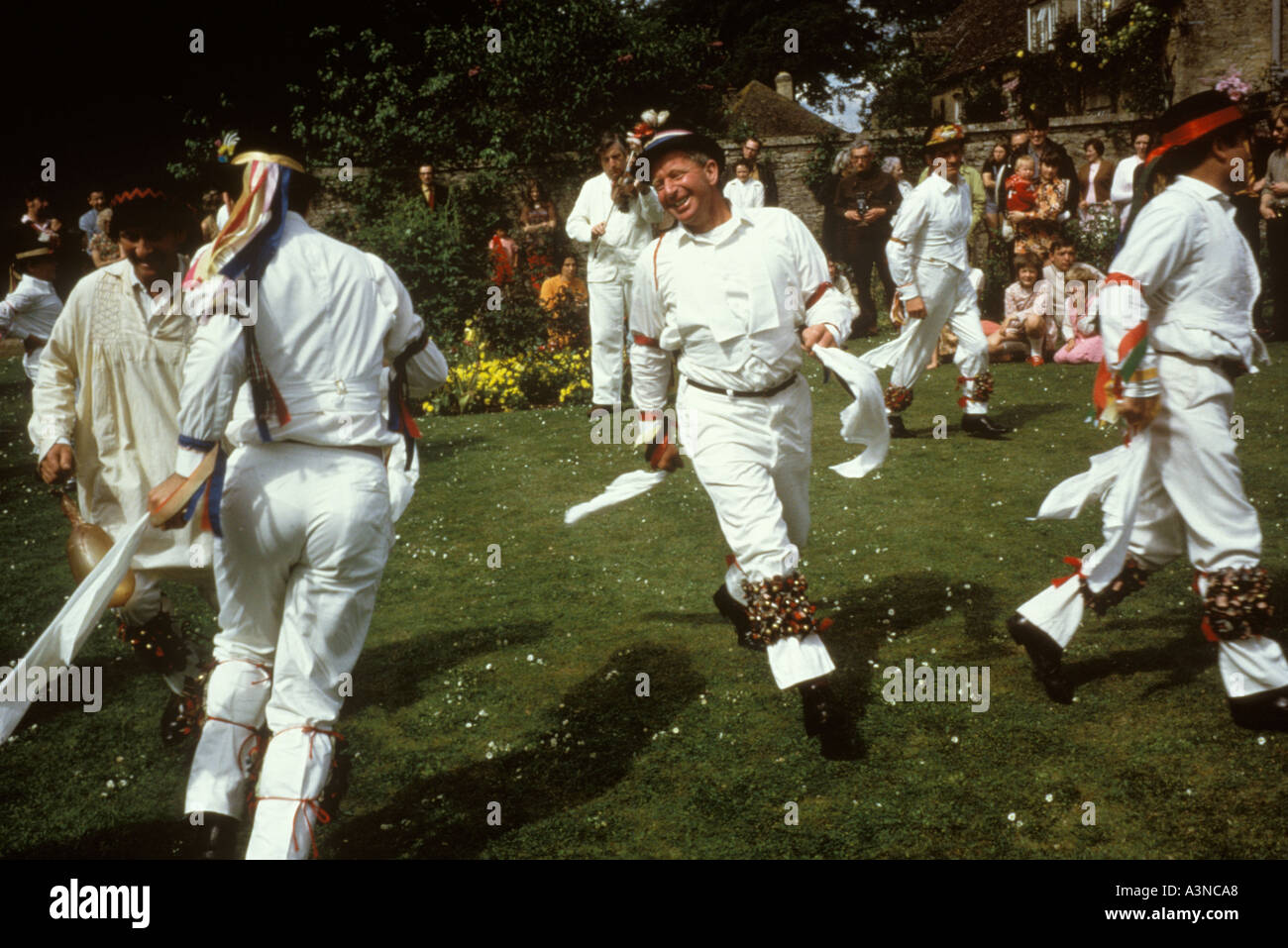 Bampton Morris Tänzer tanzen in den Gärten eines „großen“ Hauses im Dorf. 1970er Jahre Großbritannien um 1975 Ein traditionelles englisches Fruchtbarkeitsritual im Frühling. Stockfoto