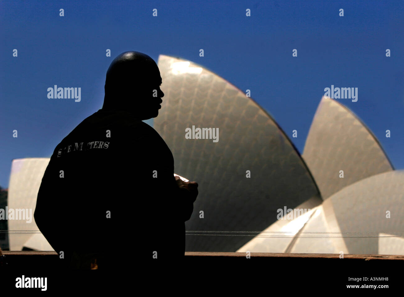 Auf die Größe kommt ein Afro-Amerikaner Wachmann im Profil zum Sydney Opera House steht Stockfoto
