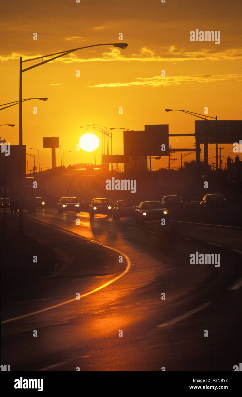 PKW und LKW im täglichen Straßenverkehr pendeln auf gekrümmten Autobahn bei Sonnenuntergang mit Sonne, Philadelphia PA USA Stockfoto