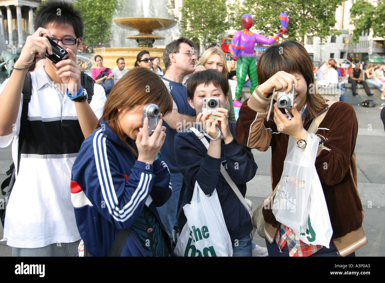 Japanische Touristen fotografieren Trafalgar square London Stockfoto