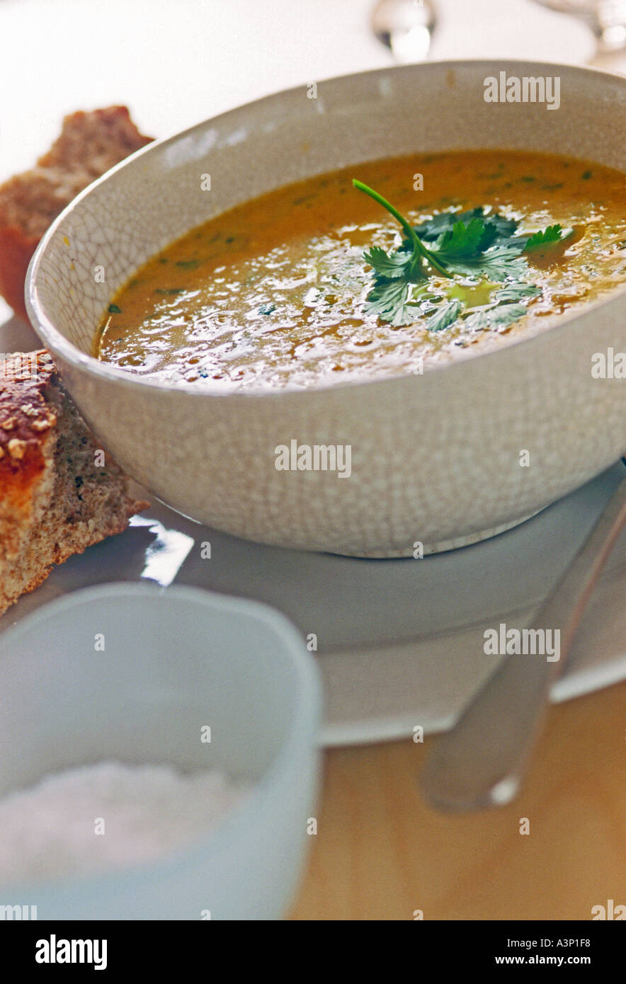 Schüssel mit Karotten-Koriander-Suppe mit knusprigem Brot Stockfoto