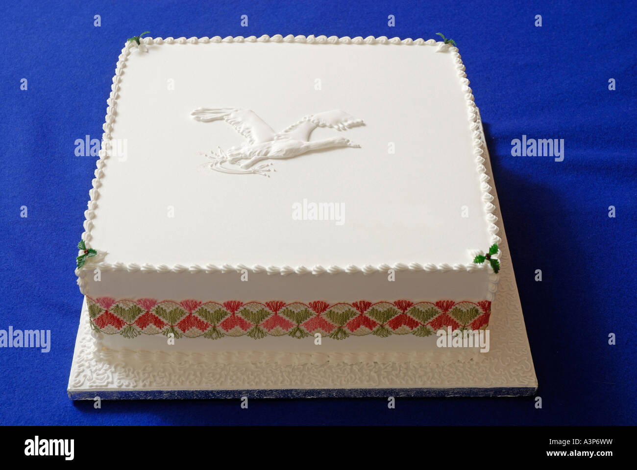 Single Tier Kuchen, dekoriert mit Royal icing, mit Bild des fliegenden Schwan auf top und von mehrfarbigen Band umgeben Stockfoto