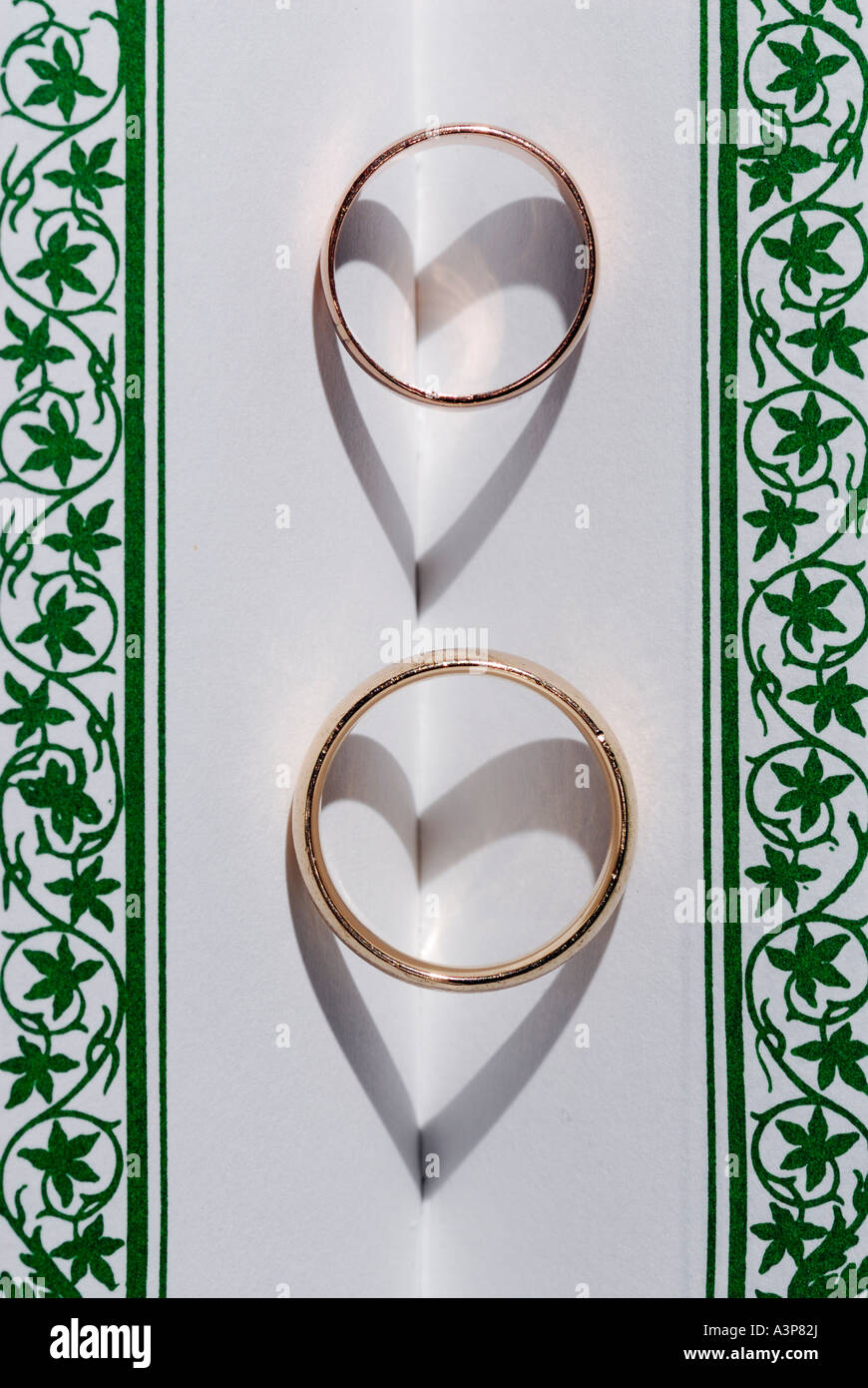 Zwei Ringe auf einen Buchrücken mit Herz Schatten für Liebe Stockfoto