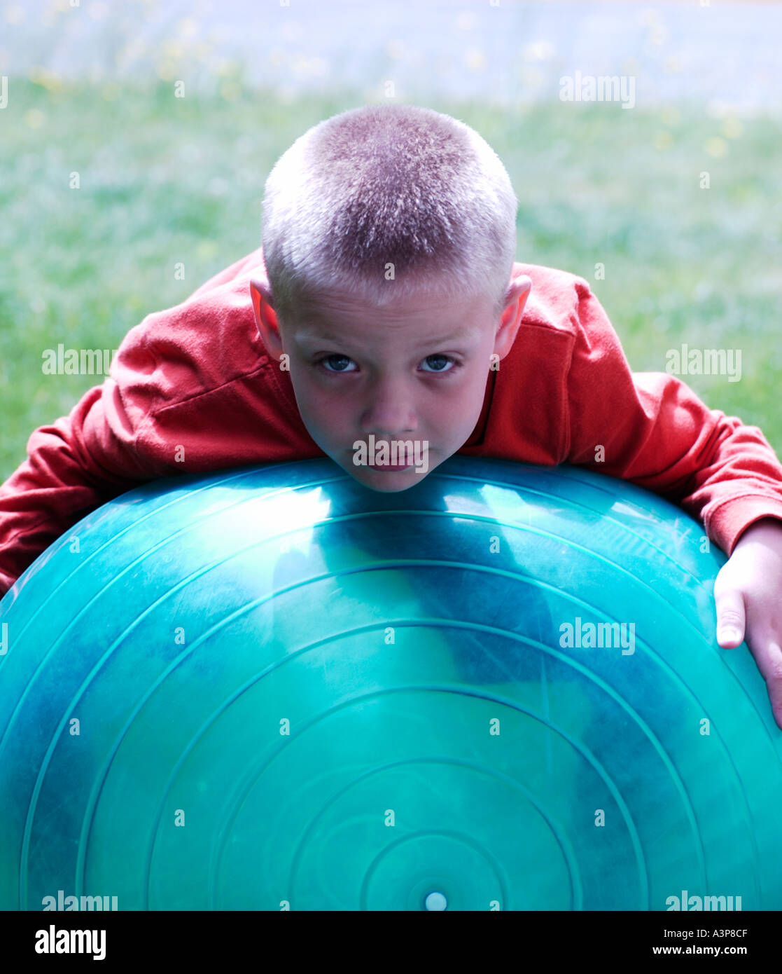 5 Jahre alter Junge Handauflegen große blaue Kugel Stockfoto