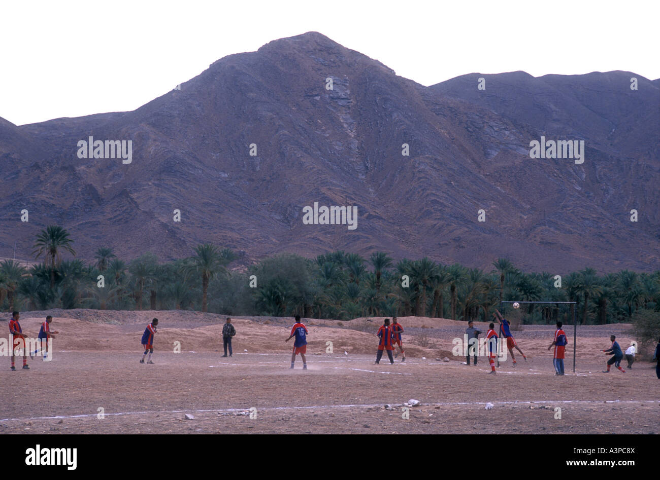Muslimische Jugendliche Fußball- oder Fußball zu spielen, in der Nähe einer Oasis im Dades Tal im Süden Marokkos Stockfoto