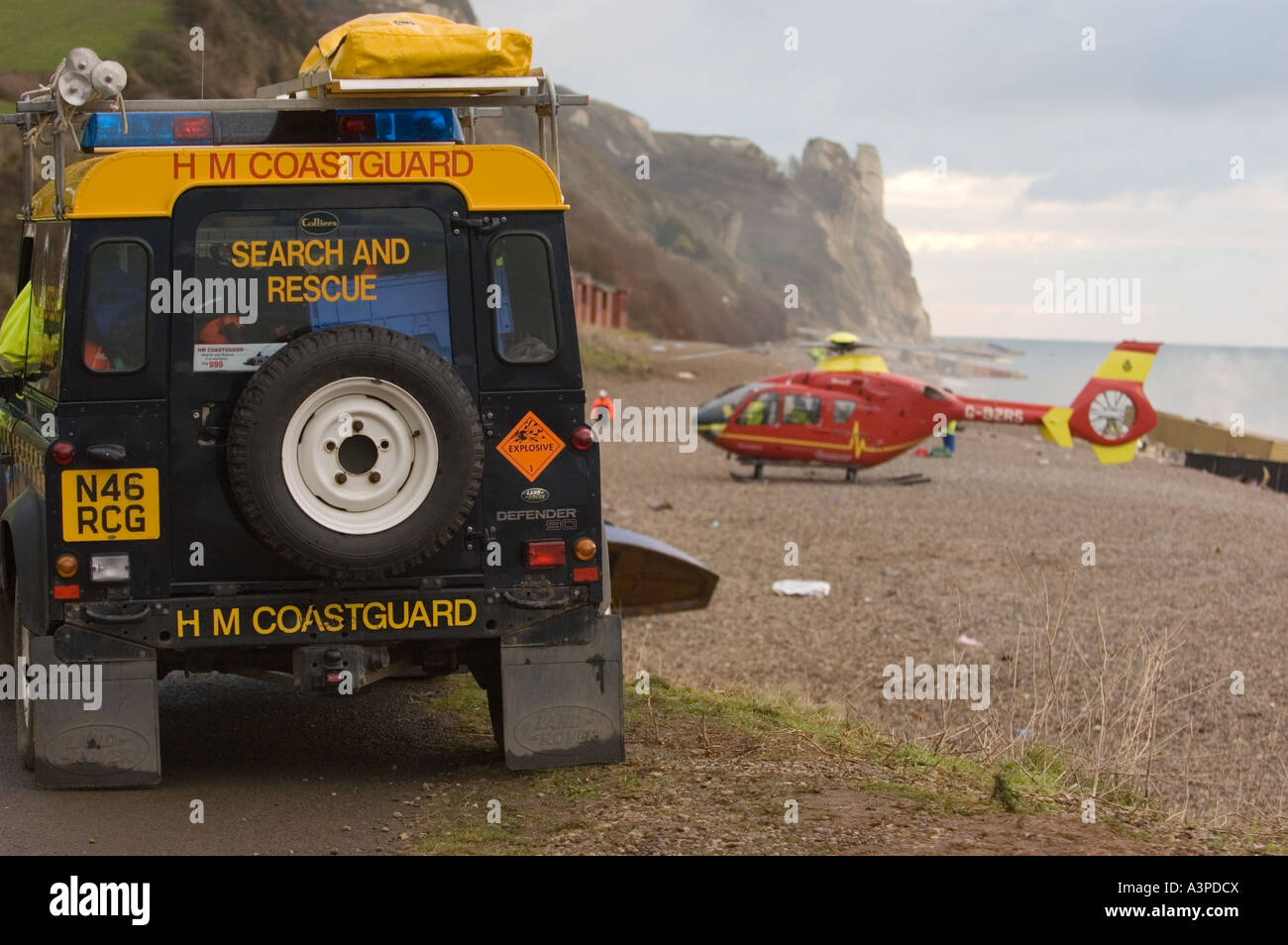 Coast Guard Landrover überwacht Flugrettung, die Landung am Strand in devon Stockfoto