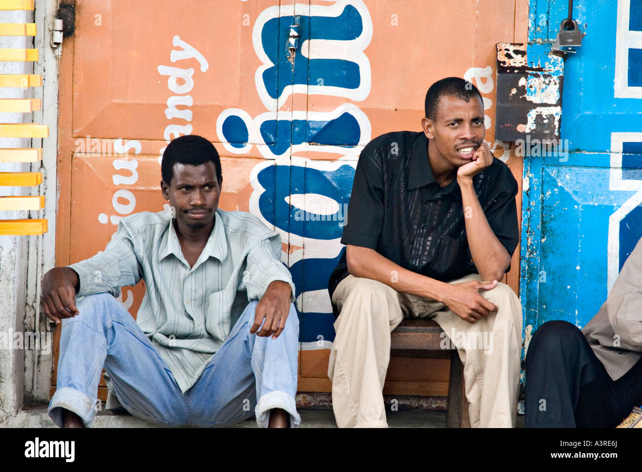Einheimische Männer chillen auf einem der Stone Town Straßen, Sansibar, Tansania, Afrika Stockfoto