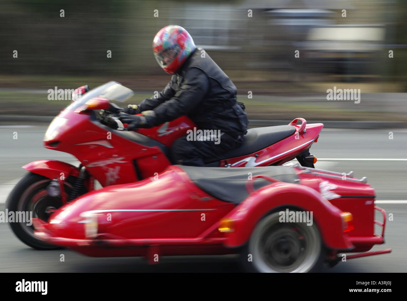 Beschleunigung verschwommene rote Motorrad und Beiwagen auf britischen Straßen Stockfoto
