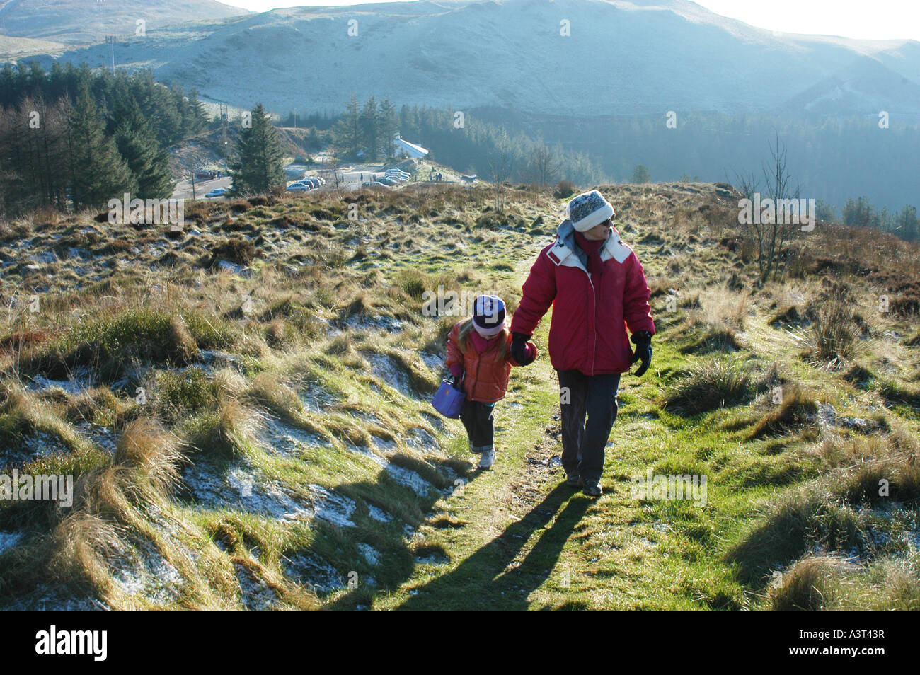 Mutter und Kind zu Fuß Nant yr Arian Park Ceredigion Wales UK an einem kalten frostigen Winter-Nachmittag Stockfoto