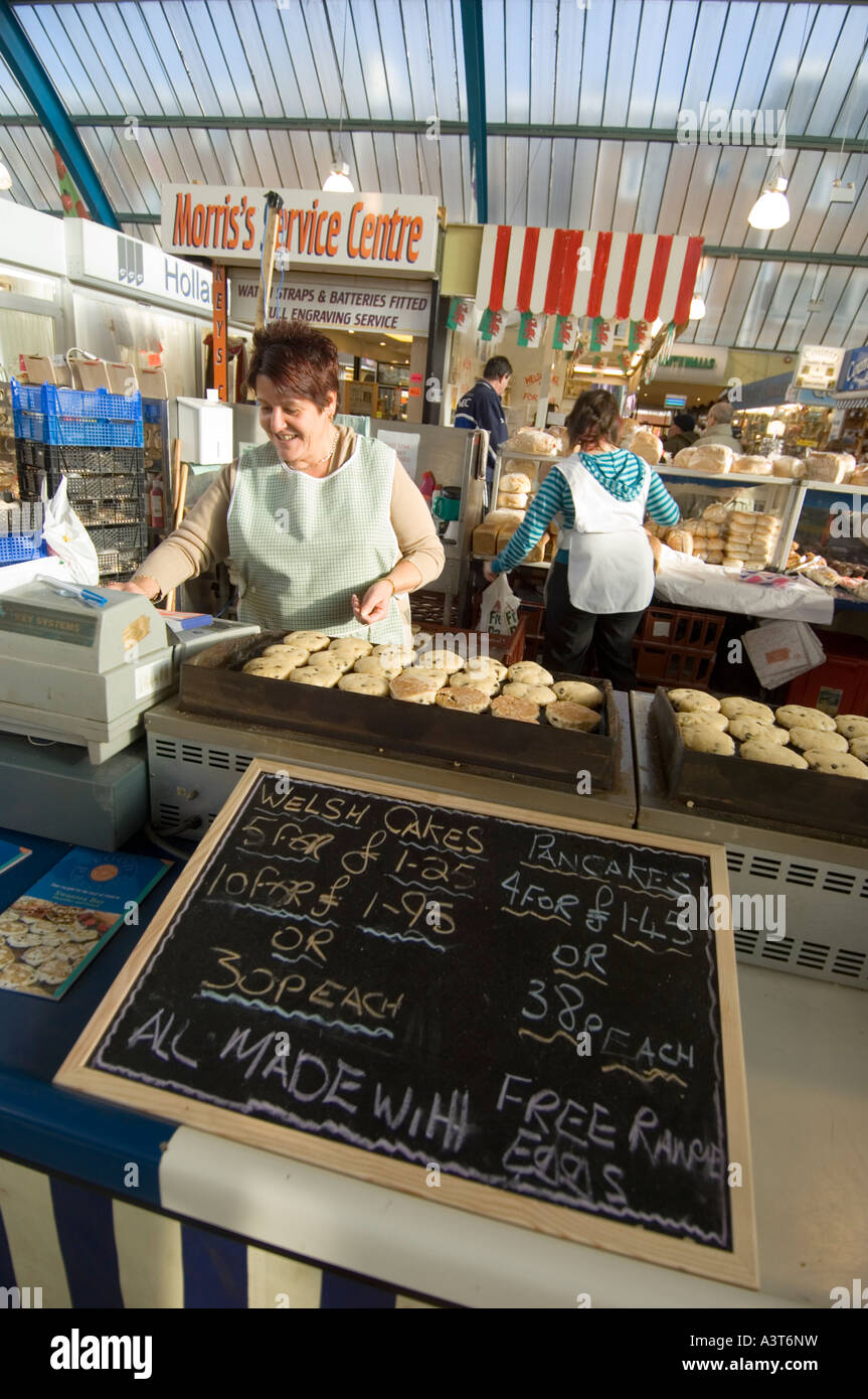 Frau Standbesitzer Kochen frisch gemacht Kuchen gekocht wird auf einem warmen Teller Bratpfanne an der Markthalle Swansea West Glamorgan Welsch Stockfoto