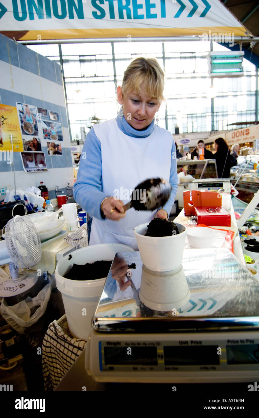Frau Standbesitzer Verkauf an Indoor-Markt Swansea West Glamorgan Wannen Laverbread vorbereiten Stockfoto