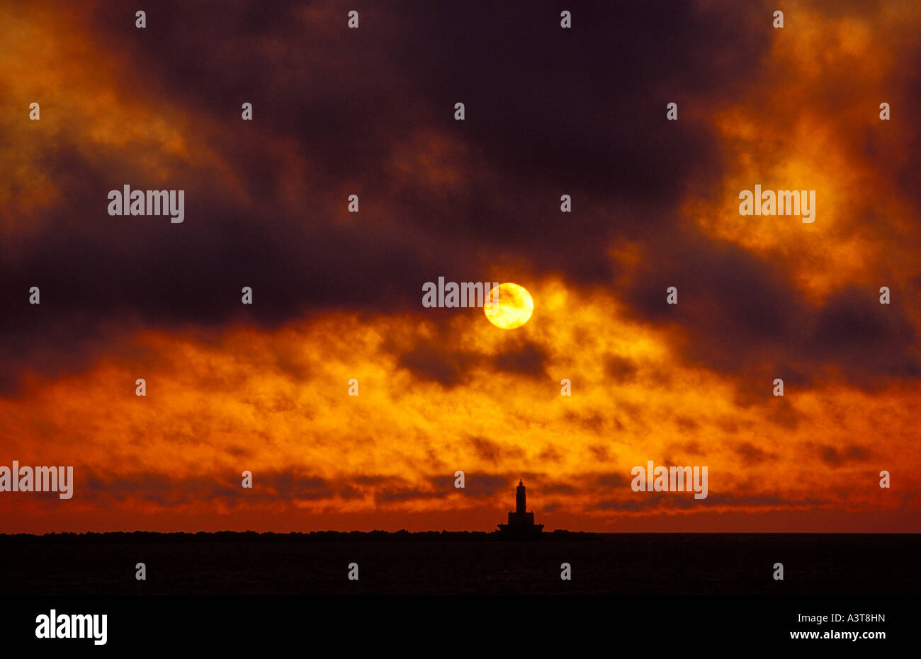 SONNENAUFGANG ÜBER OBEREN HAFEN WELLENBRECHER LICHT IN MARQUETTE MICHIGAN MIT WOLKEN Stockfoto