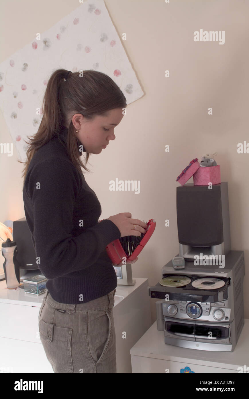 Teenager-Mädchen unter CDs von Halter zu CD-Player zulegen Stockfotografie  - Alamy