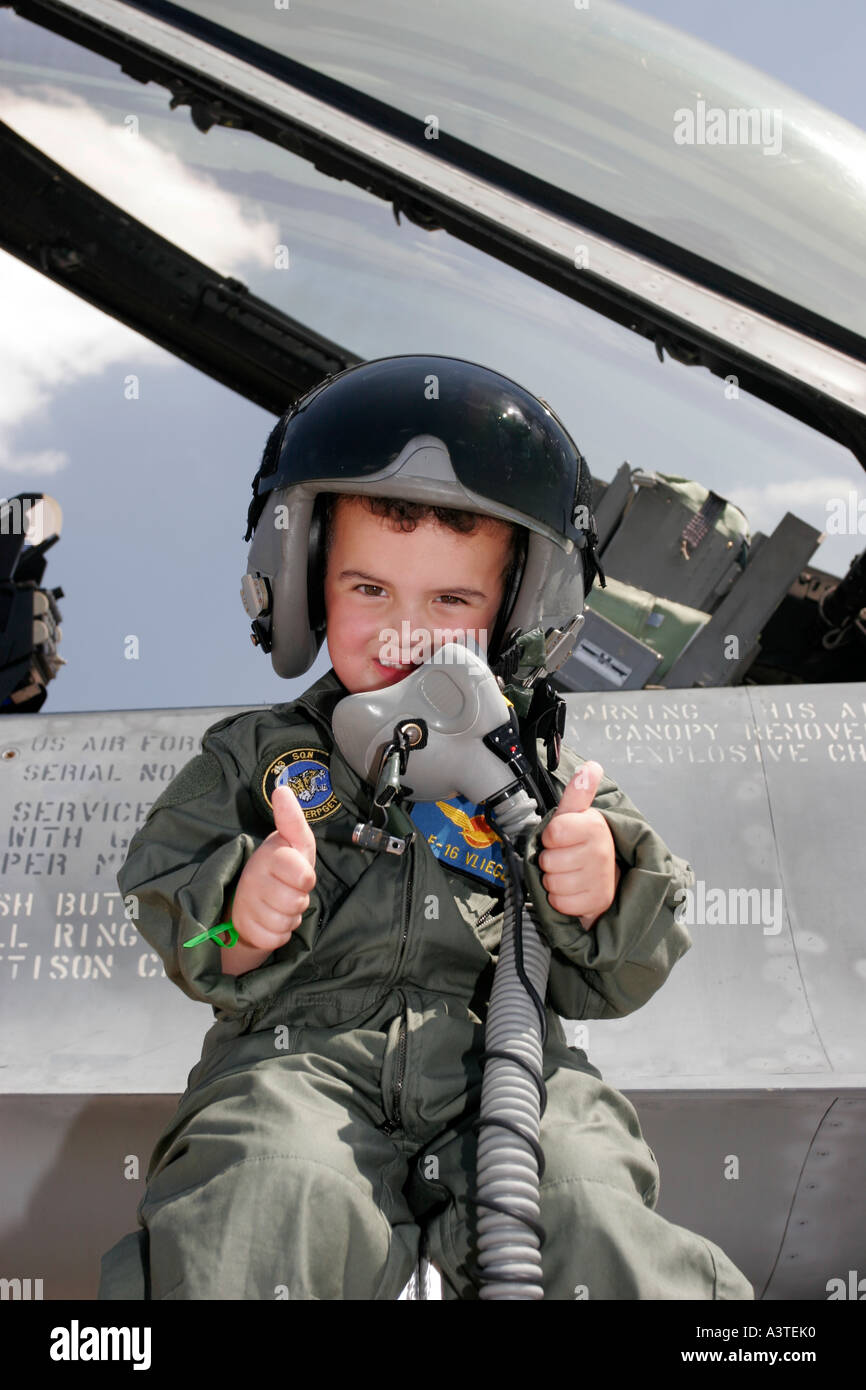 Kleiner Junge gekleidet in pilot s Overall sitzt neben dem Cockpit eine F16 Stockfoto