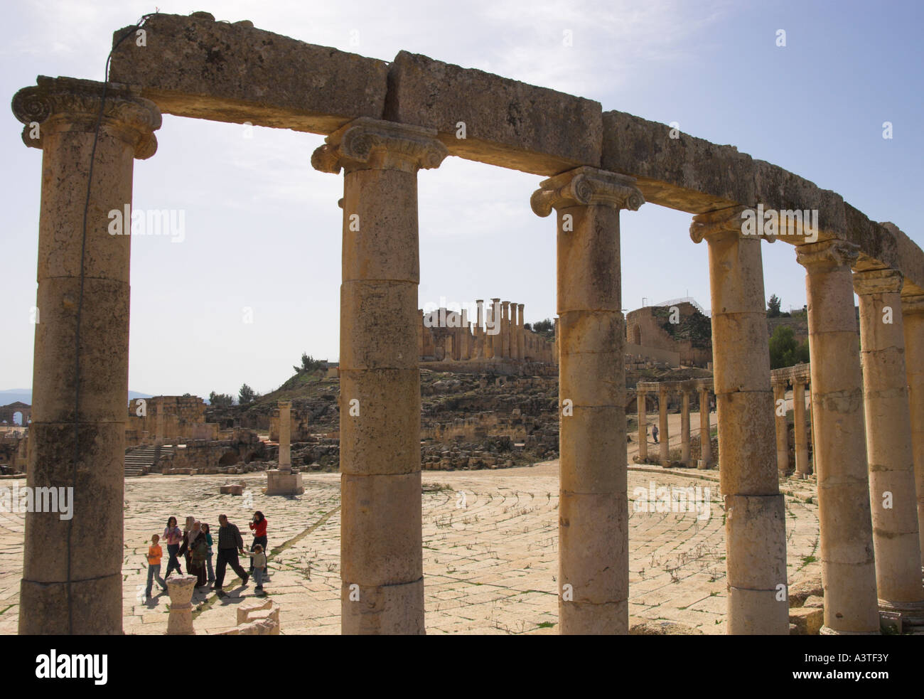 Jordan Jerash Ausgrabungsstätte Forum Hintergrundbeleuchtung Blick durch Spalten mit Familie vorbeigehen Stockfoto