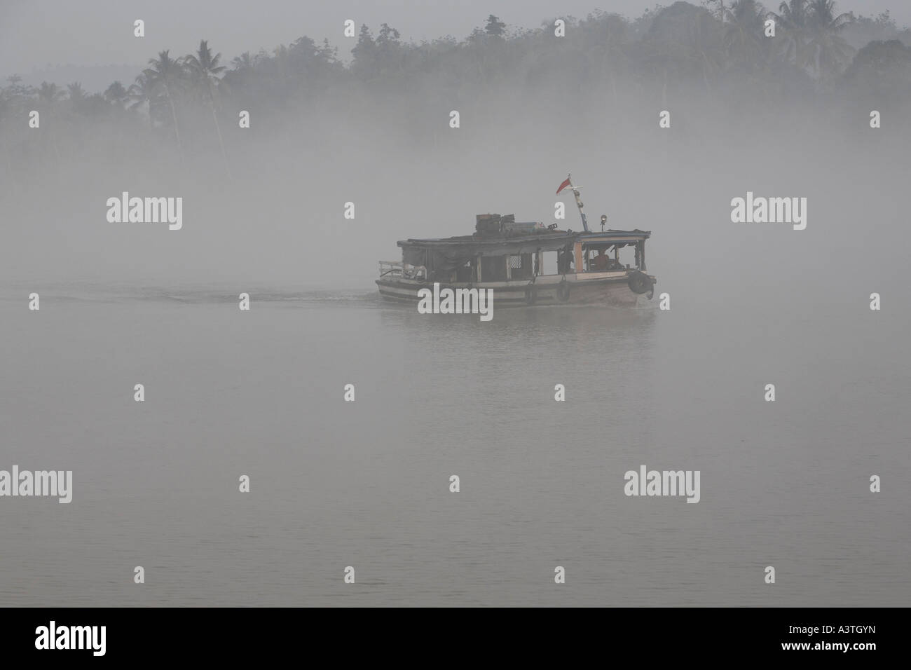 Das Schiff im Morgennebel am Fluss Sungai Mahakam, Ost-Kalimantan, Borneo, Indonesien Stockfoto