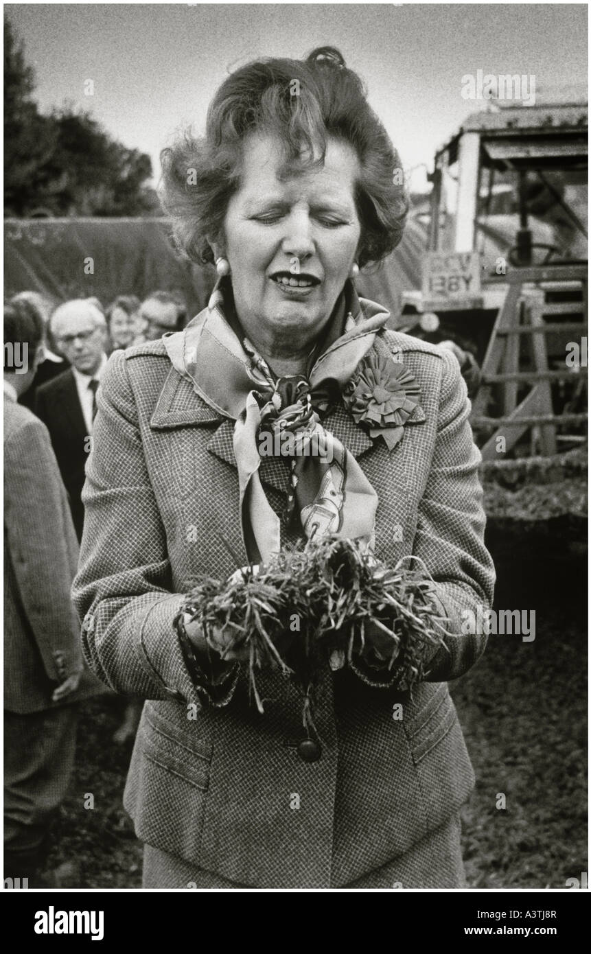 Frau Thatcher komischen Gesicht ziehen, wie sie Gülle auf einem Bauernhof abholt Stockfoto