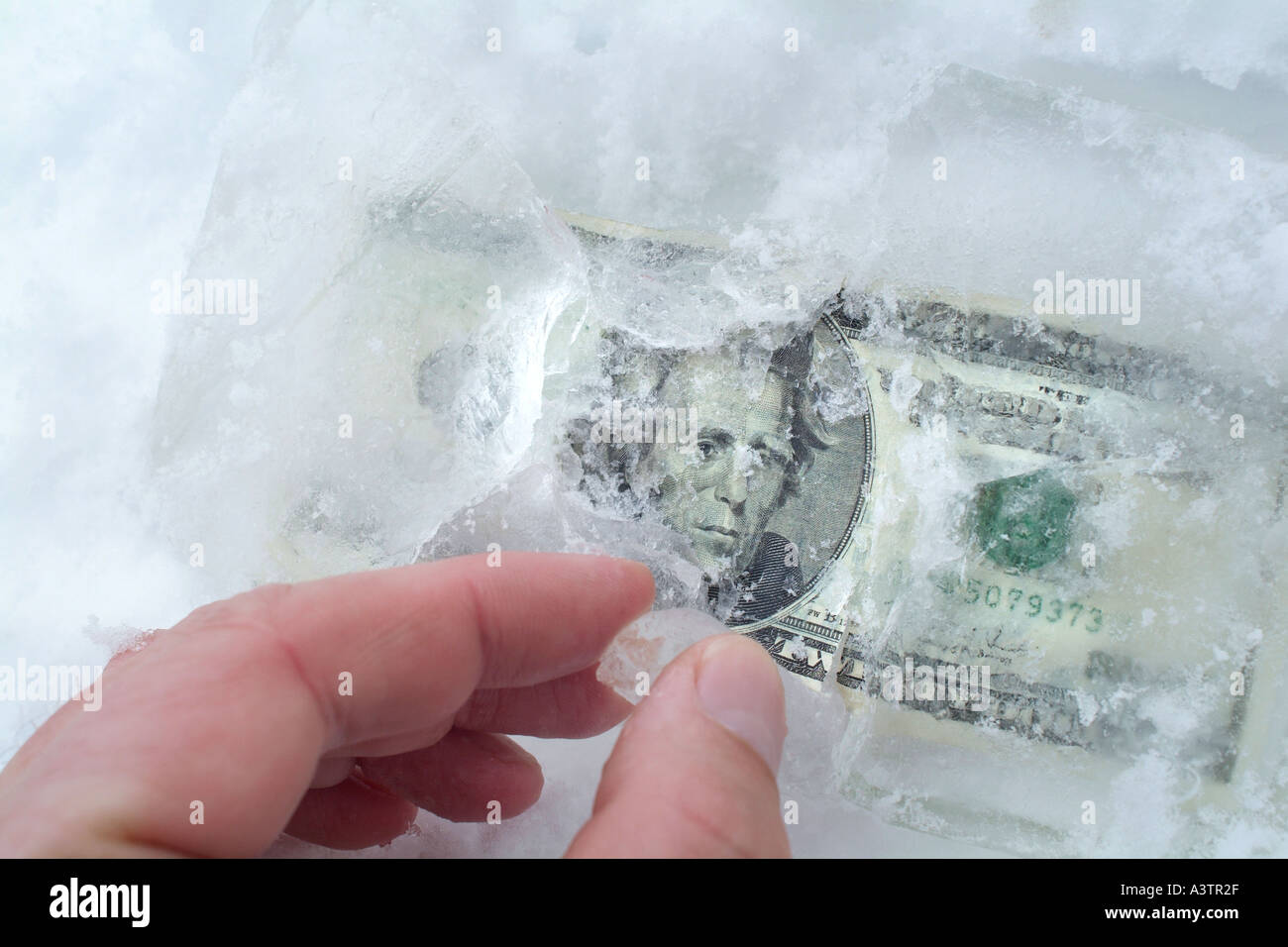 Hand in Eis eingefrorene Geld zu finden Stockfoto