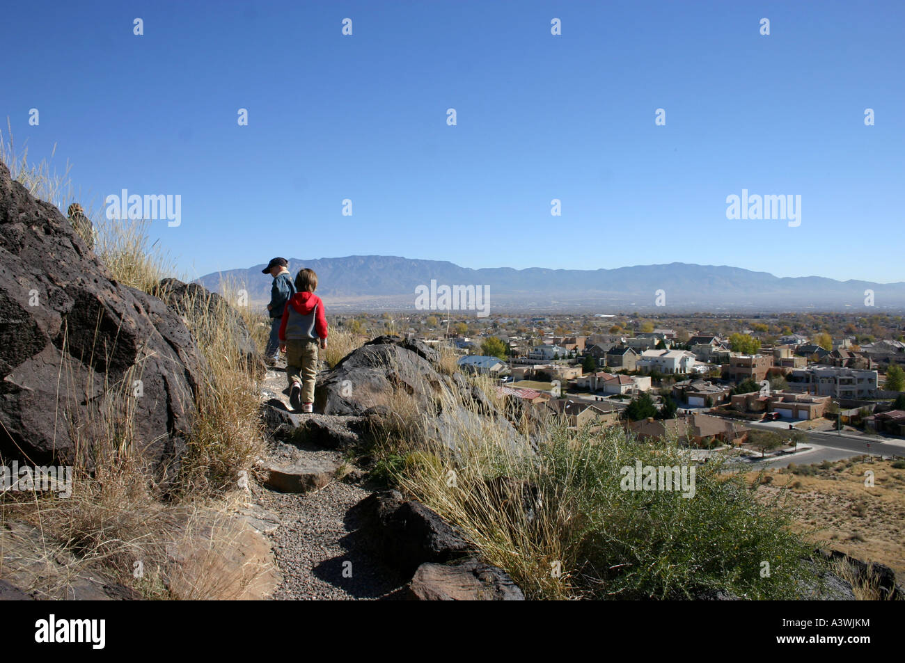 Kinder wandern entlang, Petroglyph Park in Albuquerque, NM. Nationales Denkmal hat Vorstadtgehäuse in unmittelbarer Nähe. Stockfoto