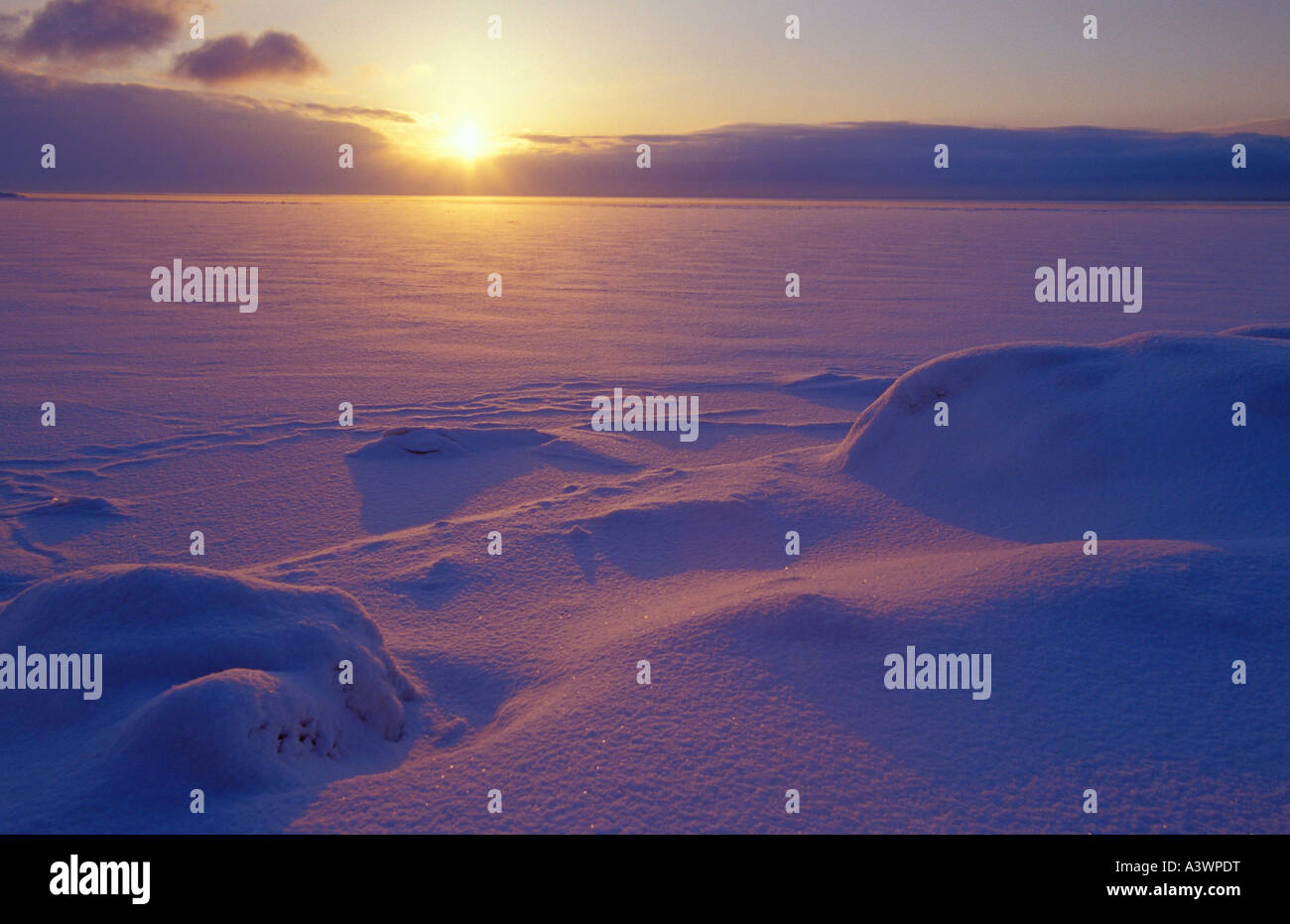 DIE SONNE STEIGT ÜBER DEN GEFRORENEN SEE SUPERIOR BEDECKT MIT FRISCHEN SCHNEE IN MARQUETTE, MICHIGAN Stockfoto