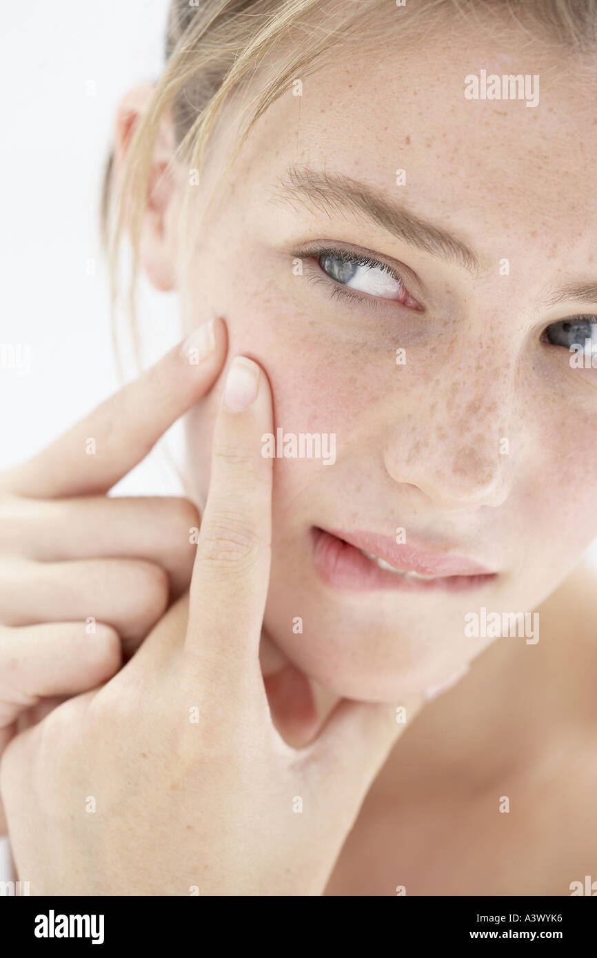 Eine junge Frau, die ihre Pickel Behandlung Stockfoto