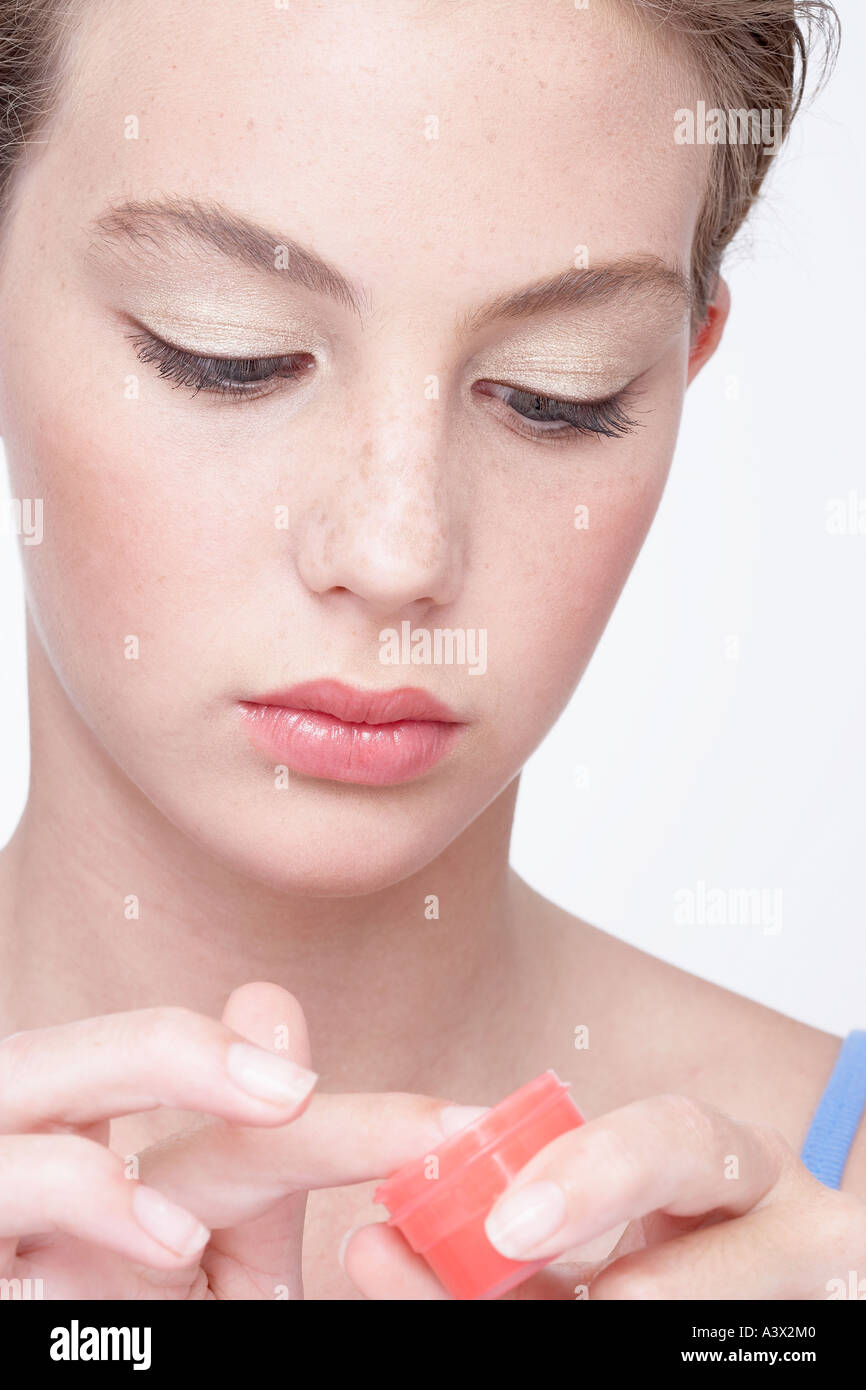 Junge Frau Anwendung Lippencreme Stockfoto