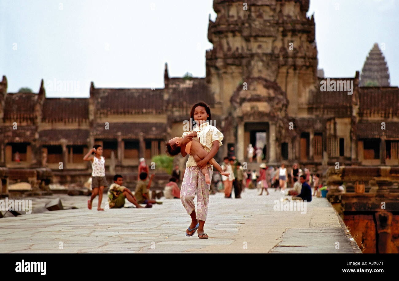 Junge Mädchen tragen Kind vor Ankhor Wat (Angkor Wat) Siem Reap Kambodscha. Ein starkes Bild. Stockfoto